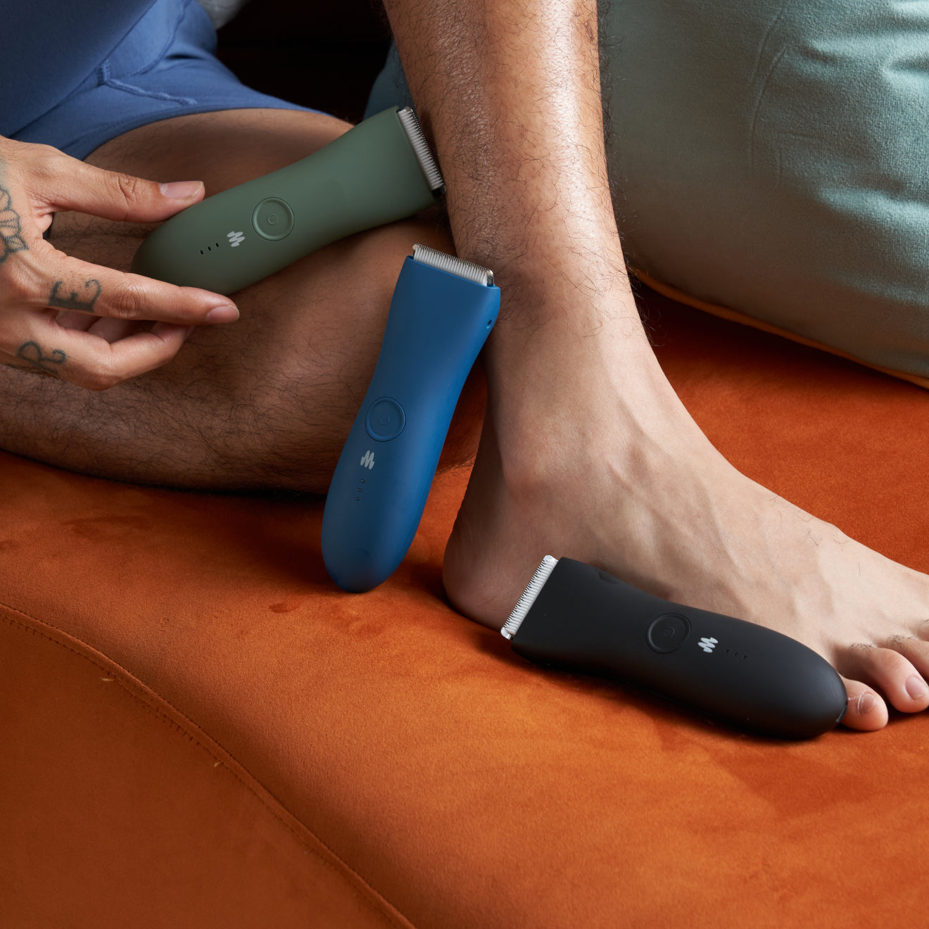 3 Meridian personal grooming trimmers next to man's legs